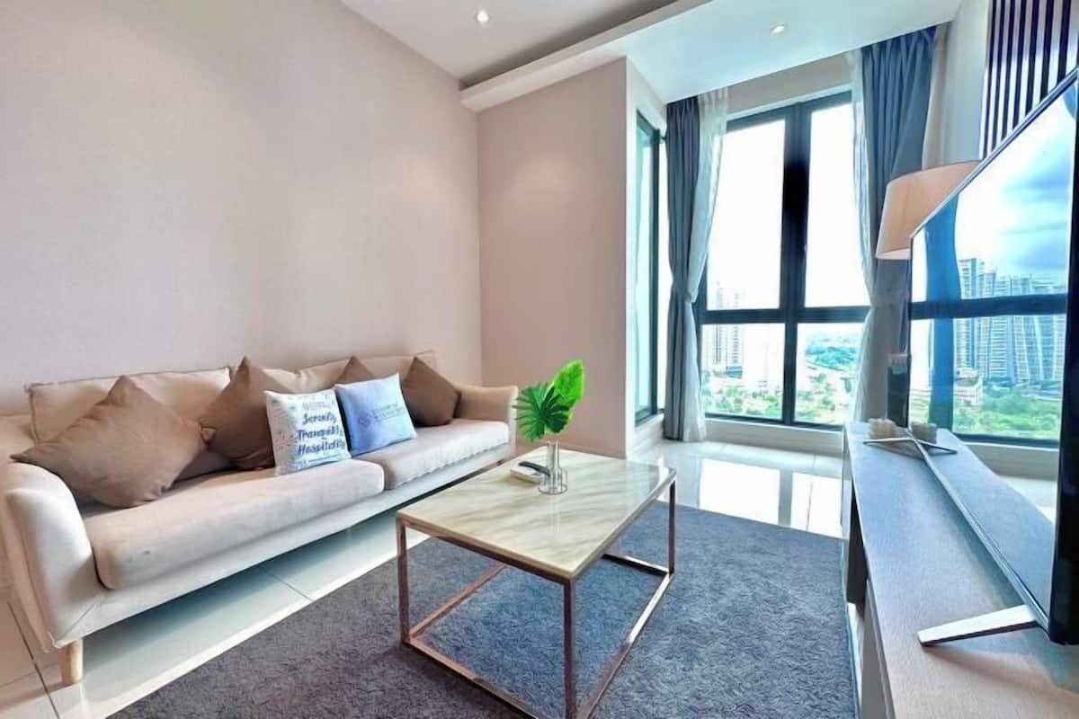 A modern living room with a sofa, a coffee table, and a large window with a city view.
