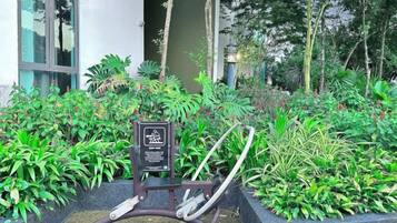 A garden area with a bench, a sign, and various plants.