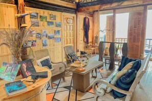 A cozy room with a wooden interior, a dining table, chairs, and a sofa.