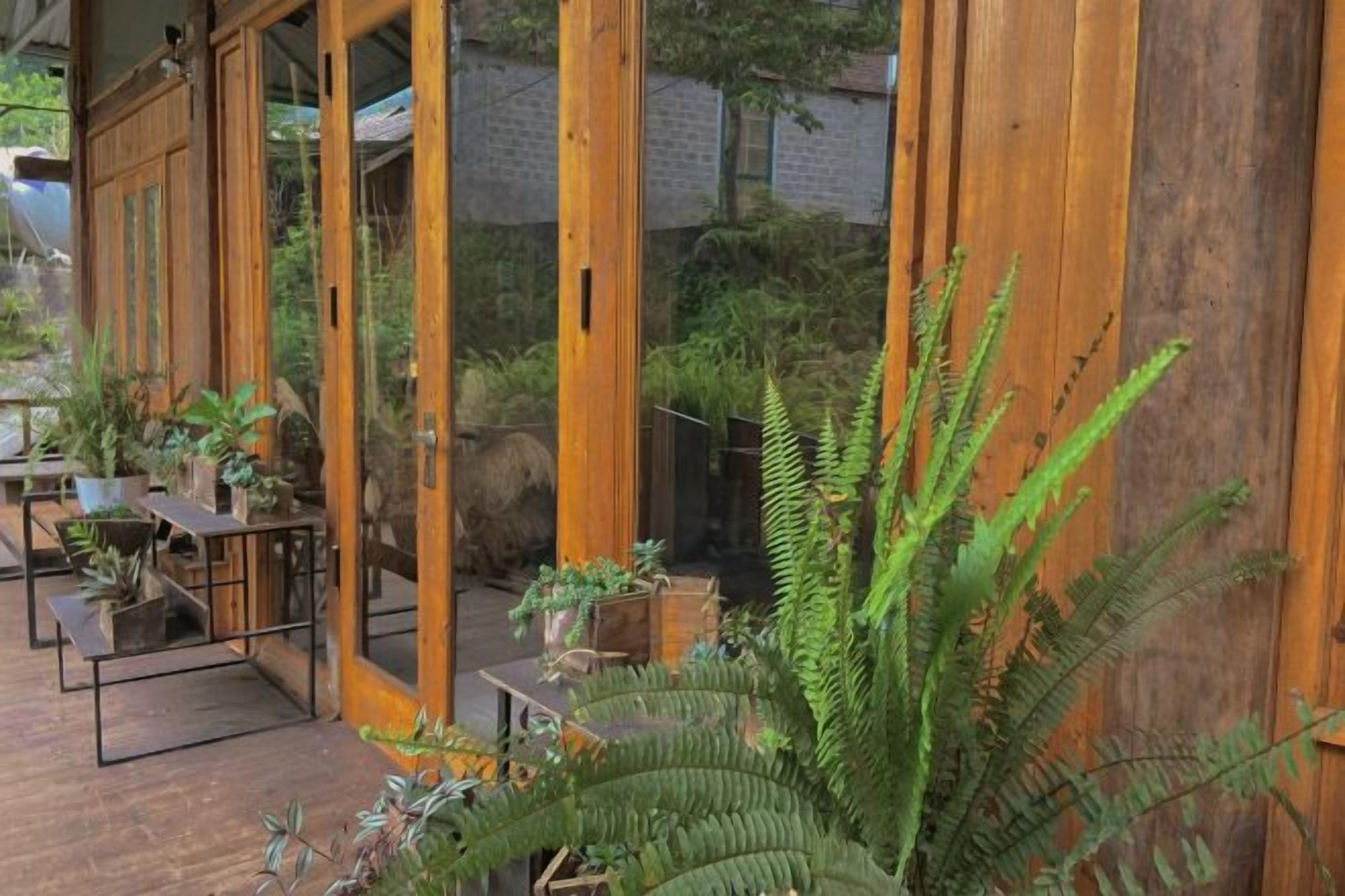 A wooden deck with potted plants and a seating area.