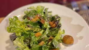 A plate of salad with lettuce and croutons.