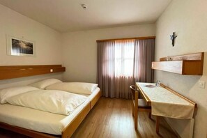 A single bedroom with a bed, a desk, and a chair. - St.Jodern (Visp)
