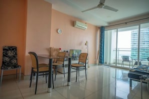 Una sala de estar moderna con comedor, ventanas amplias y vista a la ciudad.