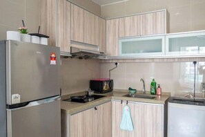 A compact kitchen with a refrigerator, microwave, stove, and dishwasher. - 2-bedroom condo with free parking on premises. (George Town)