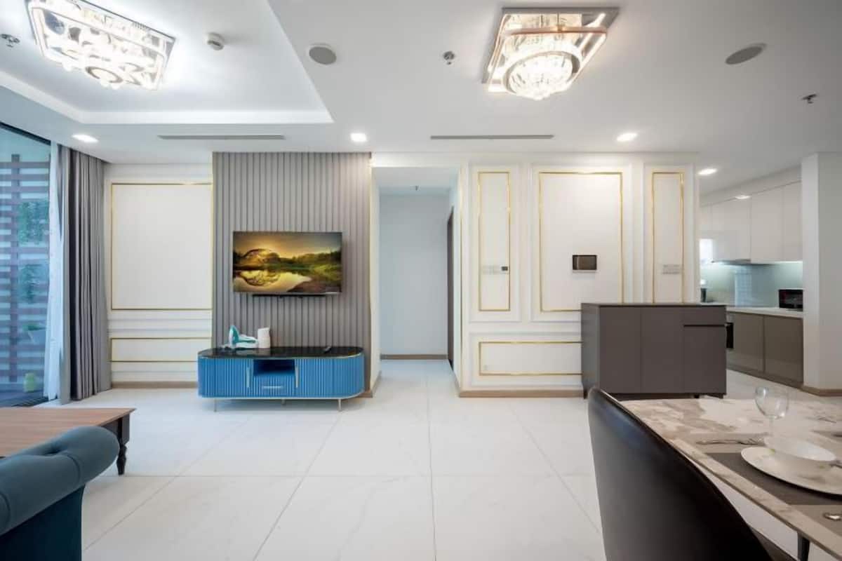 A modern interior with a dining area, a kitchen, and a living space with a flat-screen TV.