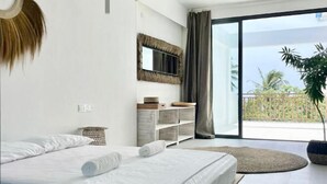 A modern bedroom with a large bed, a mirror, a plant, and a balcony with a view. - Samura Panorama Guest House (Thulusdhoo)