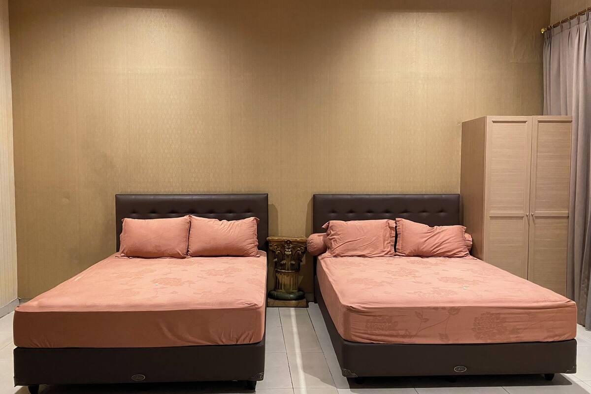 Habitación doble con dos camas, un armario y una mesita de noche.