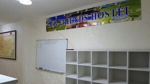A hostel room with a whiteboard, a map on the wall, and a large poster advertising 'UB FRIENDS HOSTEL'. - UB Friends Hostel (Ulaanbaatar)
