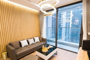 Una sala de estar moderna con un sofá, una mesa de centro y un ventanal con vistas a la ciudad.