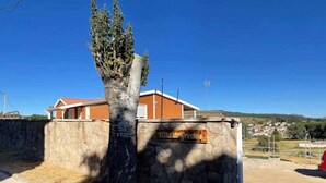 Un mur de pierre sur lequel est fixée une plaque en bois portant l’inscription « Villa Gregor ».