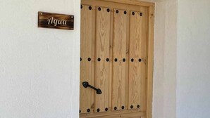 Une porte en bois avec une poignée en métal et une pancarte au-dessus indiquant le mot « Agua ».
