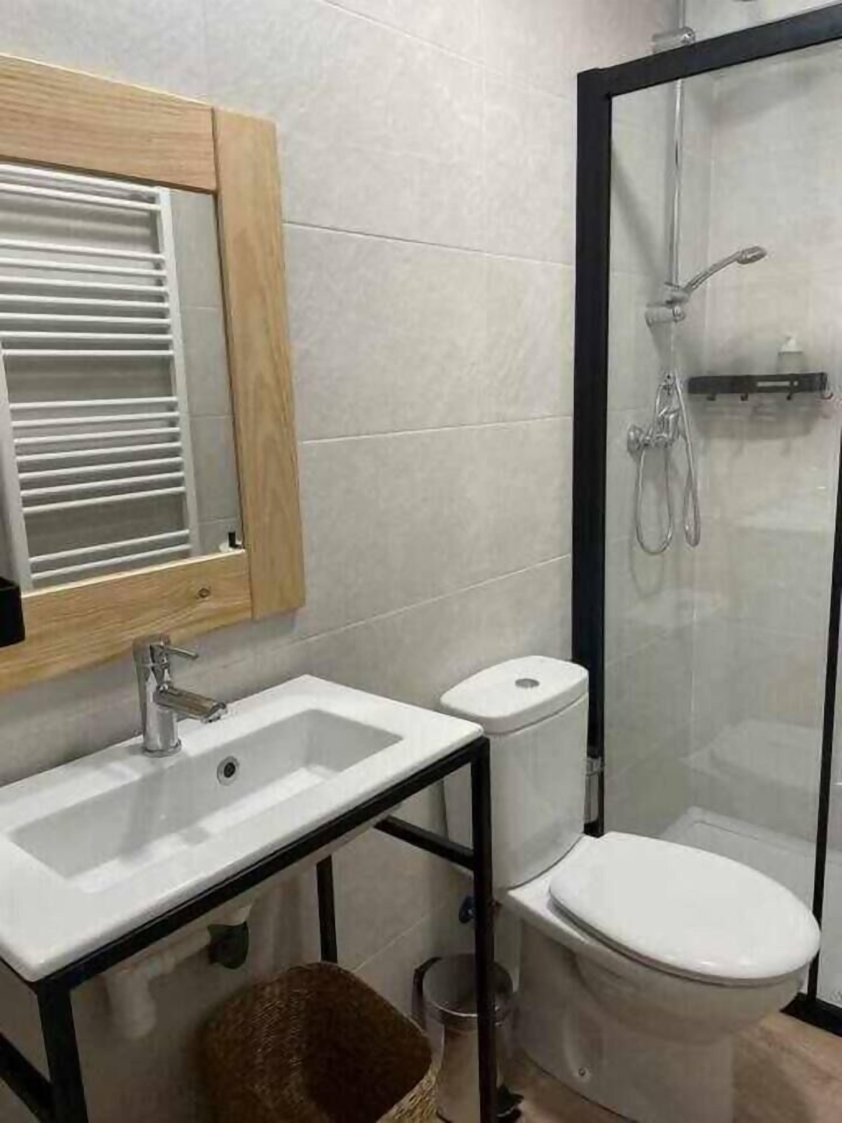 Un baño con lavamanos, inodoro y ducha.