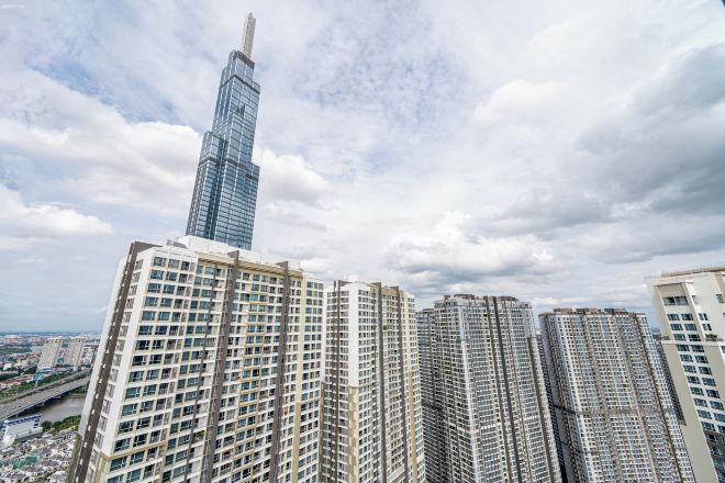 A high-rise building with a distinctive spire, surrounded by other tall residential buildings.
