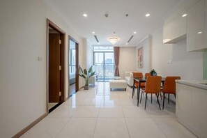 A modern interior with a dining area, a kitchen, and a view of the outdoors. - Vinhomes Central Park - PHAN DANG Residences (Ho Chi Minh City)