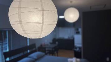 A room with a bed, a desk, and a hanging spherical light fixture.