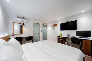 A hotel room with a bed, desk, chairs, a TV, and a small kitchenette. - Jamsil Noblestay Hotel (Seoul)