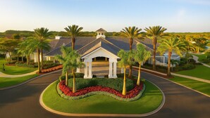 A large building with a central pavilion, surrounded by palm trees and well-maintained lawns. - Horse Creek Retreat (Fort Myers)