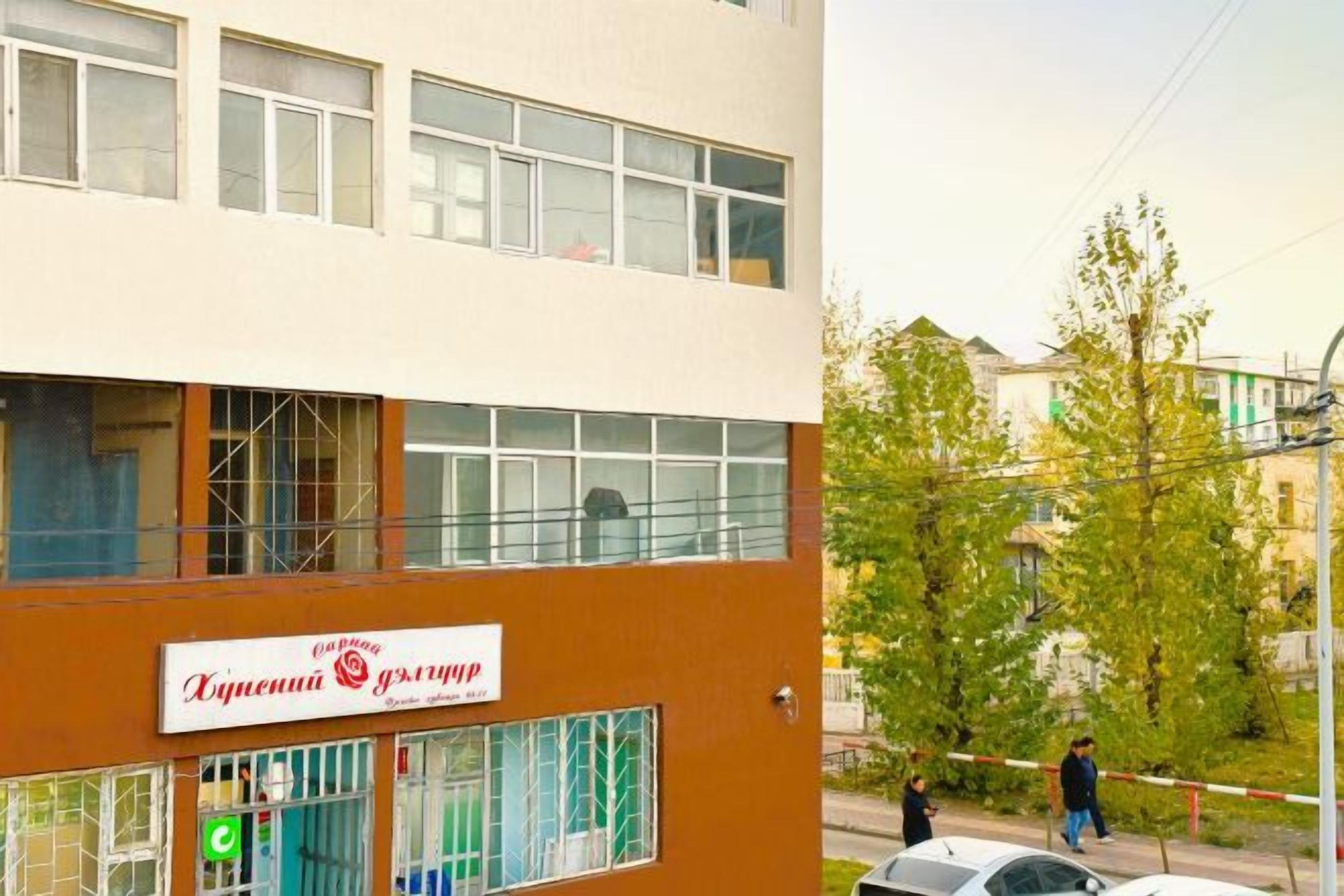 A two-story building with a sign indicating a business or service establishment on the ground floor.