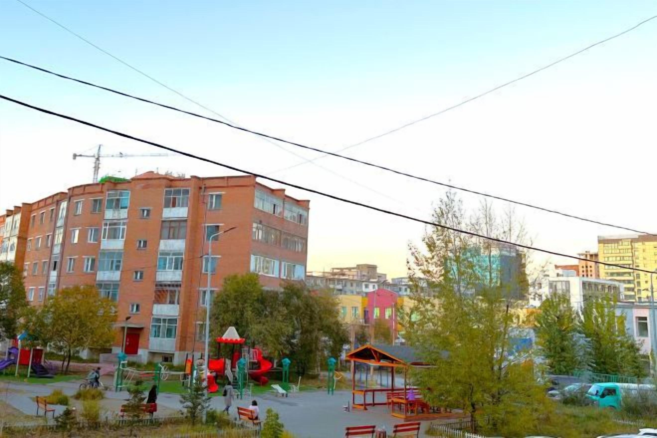 A multi-story building with a playground in the foreground.