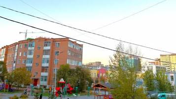 A multi-story building with a playground in the foreground.