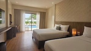 A hotel room with two beds, a desk, and a view of a swimming pool. - Lotus Resort Panglao (Panglao)