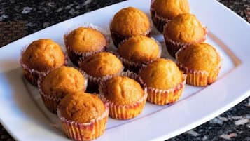 A white plate with round, golden-brown baked goods in paper cups.