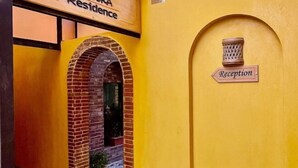 A reception area with a sign indicating 'Reception' and a brick archway leading to a door. - Al Dora All Inclusive Hotel (Hurghada)