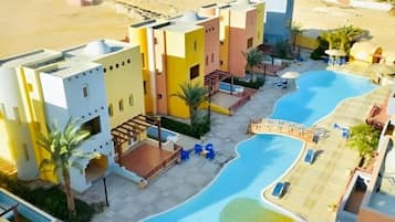 Een hotel met meerdere gebouwen, een zwembad en uitzicht op het strand.