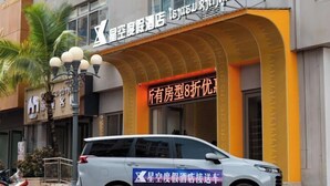 A hotel with a prominent sign advertising a 8-fold discount on other hotel rooms. - Starry Sky Resort Hotel (Boten)