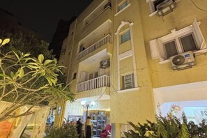 A multi-story building with balconies, air conditioning units, and a ground-level entrance. - Bafang Homestay (Cairo)
