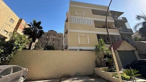 Un edifici residencial de diverses plantes amb façana de maó, balcons i un llum de carrer.