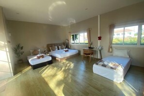 Une chambre d’hôtel avec deux lits, un bureau et une chaise.