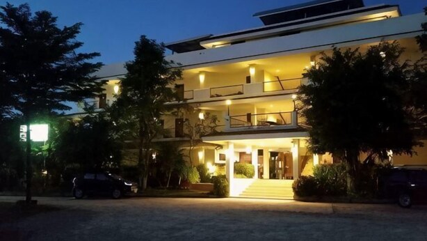 A multi-story hotel with a flat roof, a balcony on the second floor, and a well-lit entrance. - Imboutique hotel Maesot (Mae Sot)