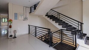 A modern interior with a staircase, a flat floor, and a wall-mounted electrical panel. - Urbanview Hotel WG Jimbaran Bali (Bali)