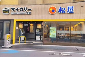 A restaurant with a yellow awning and a menu board outside. - COZY TOKYO (Tokyo)