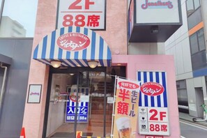 A building with a sign indicating '2F 88th floor' and 'Coffee & Restaurant' with a striped awning. - COZY TOKYO (Tokyo)