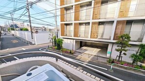 A modern building with a multi-story structure, a covered outdoor area, and a road with a speed limit sign.