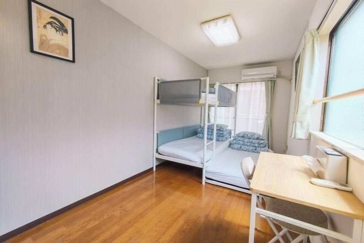 A room with a bunk bed, a desk, and a chair.