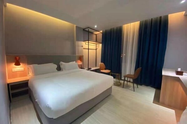 A modern hotel room with a large bed, bedside tables, a desk, and a chair. - Fucheng International Hotel (Vientiane)