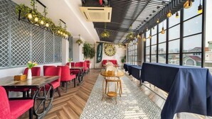 En restaurant med røde stole, træborde og et tæppe med mønster.