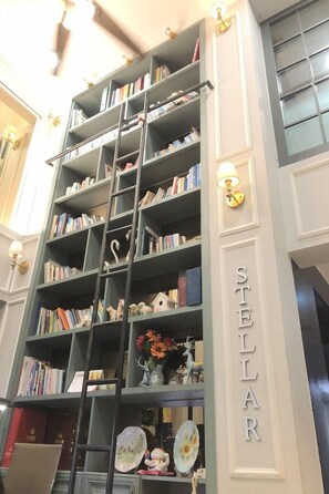 Una estantería con varios estantes llenos de libros y objetos decorativos.