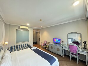 A hotel room with a bed, a desk, a chair, a television, and a wardrobe. - Stellar Boutique Hotel (Ho Chi Minh City)