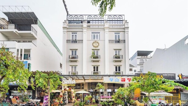 Un hotel con balcón, un cartel que dice 'Stellar Boutique Hotel' y un escaparate con un letrero que indica 'LEOPARD'.
