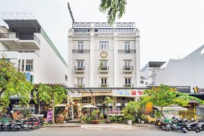 A hotel with a balcony, a sign for a boutique hotel, and a storefront with a sign for a restaurant. - Stellar Boutique Hotel (Ho Chi Minh City)