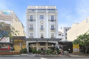Un edificio a più piani con un ingresso centrale, balconi e un orologio sulla facciata.