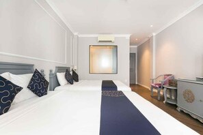 Une chambre d’hôtel avec deux lits, un grand miroir, une commode et une chaise.