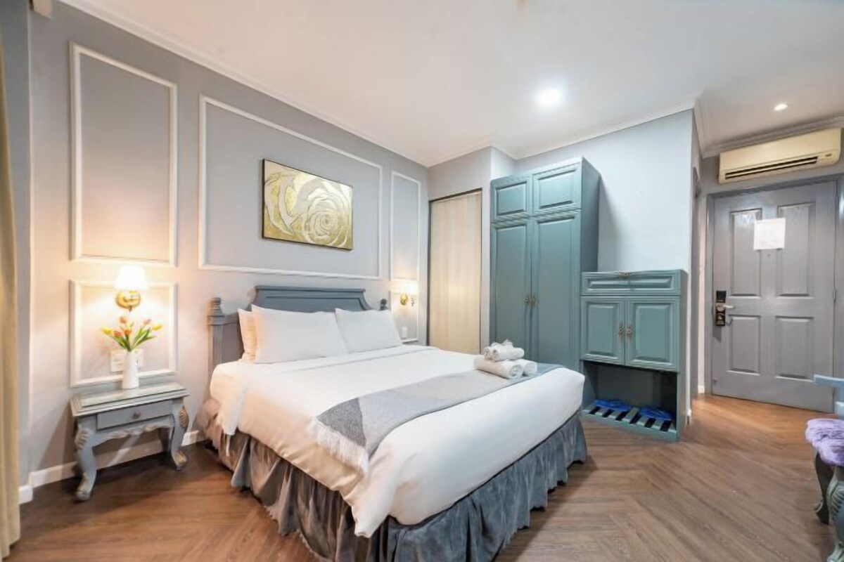 Un dormitorio ordenado con cama, mesitas de noche, un armario y una puerta.