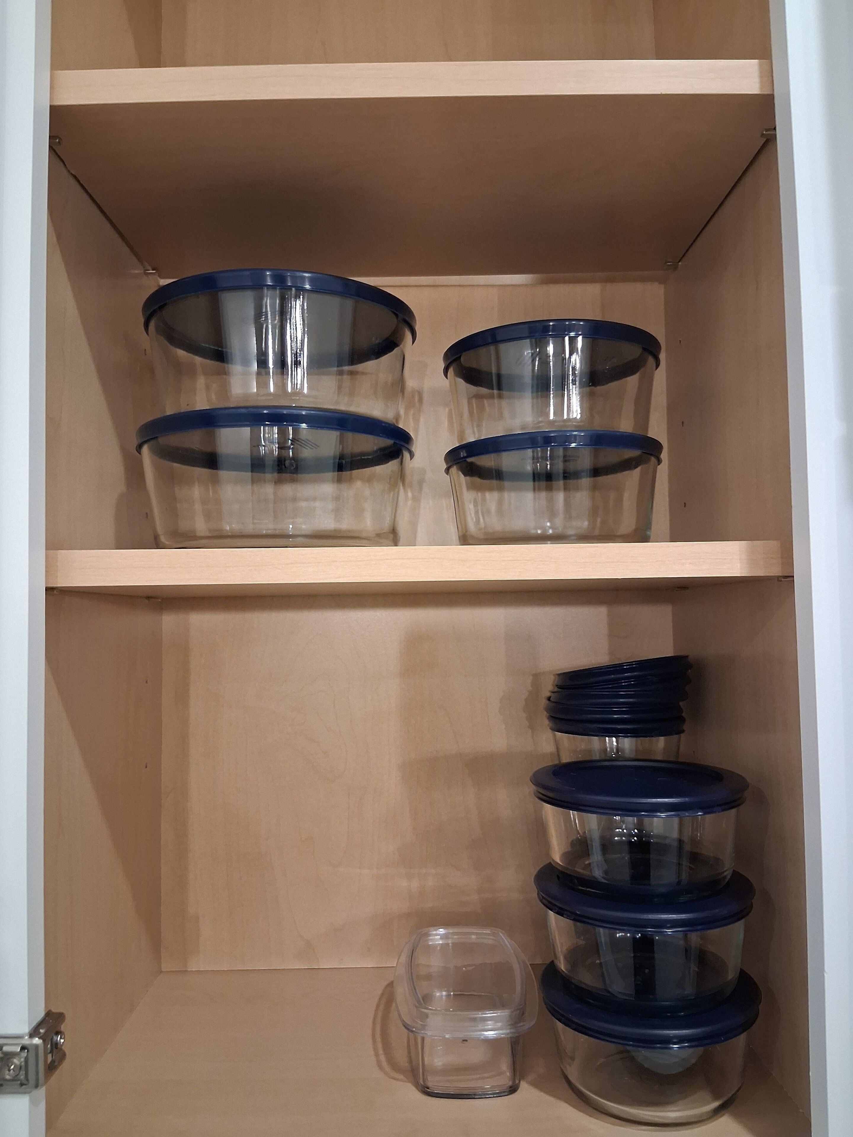 Un mueble de madera con tres estantes, cada uno con recipientes de plástico transparente y tapas azules.