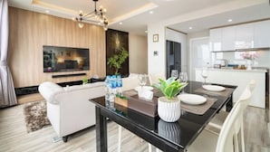 Una sala de estar moderna con sofá, mesa de comedor y zona de cocina.