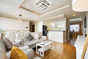 Una sala de estar moderna con un sofá, una mesa de centro y una cocina al fondo.